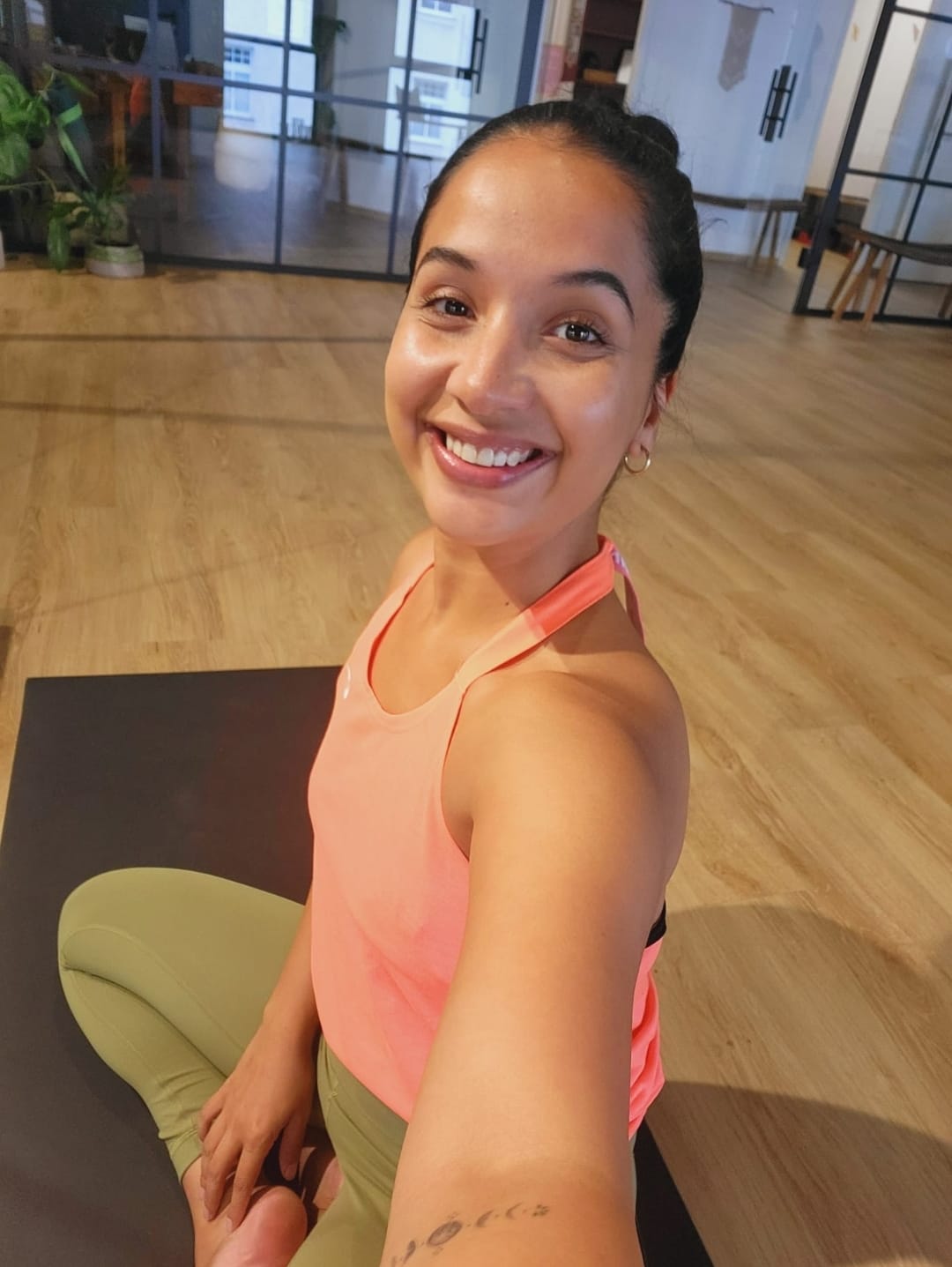Ilya Ballier, Yogalehrerin, sitzt in ruhiger Umgebung auf einer Yogamatte