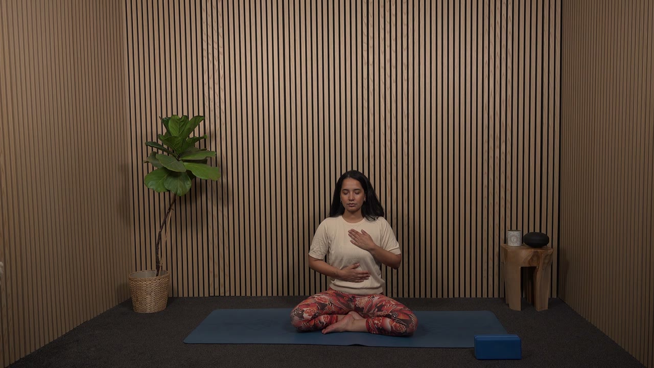 Ilya Ballier sitzt auf der Yogamatte, Einheit Inneres Strahlen